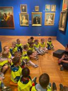 Dzieci siedzą na podłodze w muzeum.