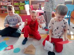 dzieci siedzą na dywanie oglądają kartki walentynkowe
