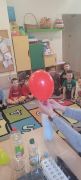 dzieci siedzą na dywanie oglądają eksperymenty