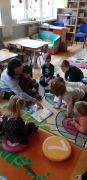 dzieci siedzą na dywanie