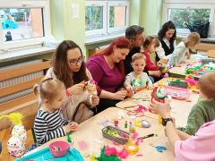 rodzice z dziećmi siedzą przy stołach