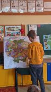 chłopiec stoi przy mapie