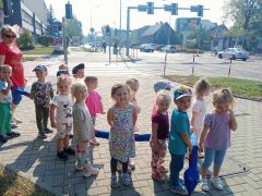 dzieci idą chodnikiem przy ulicy