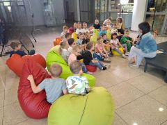 Dzieci siedząc na pufach słuchają opowiadania