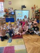 dzieci siedzą na dywanie pozują do zdjęcia