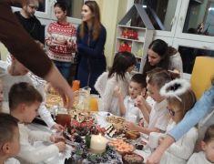 dzieci konsumują przy stolikach poczęstunek