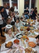 dzieci konsumują przy stolikach poczęstunek