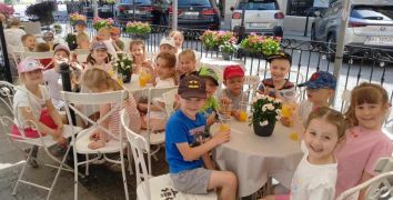 Dzieci siedzą przy stolikach w kawiarni
