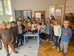 Dzieci pozują do zdjęcia przy stoliku z wagami.