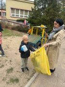 Dzieci sprzątają okolice przedszkola segregują śmieci.