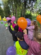 Dzieci z przedszkola na wspólnym spacerze z balonami.